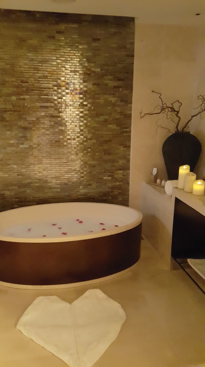 With a dash of rose petals, bubbles, salts, and scent. Then add romantic electronic candles, plus a heart-shaped rug. Voila! We have a romanntic bathtub set-up.